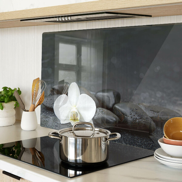 Schneidebrett mit Motiv einer Orchideenblüte auf Steinen