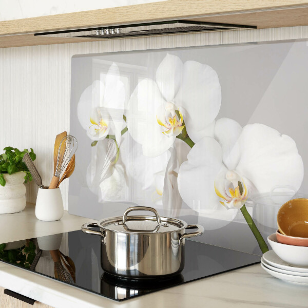 Schneidebrett mit Orchideen vor spiegelndem Hintergrund