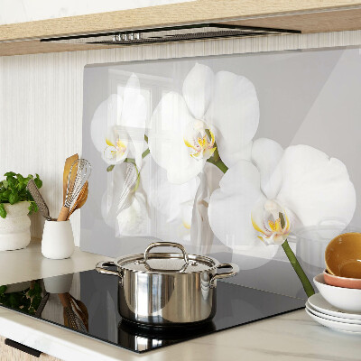 Schneidebrett mit Orchideen vor spiegelndem Hintergrund