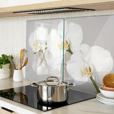 Schneidebrett mit Orchideen vor spiegelndem Hintergrund