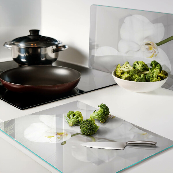 Schneidebrett mit Orchideen vor spiegelndem Hintergrund