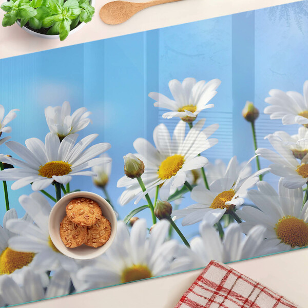 Schneidebrett glas Gänseblümchen auf blauem Hintergrund