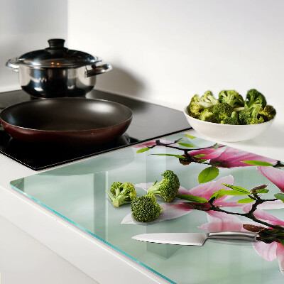 Schneidebrett Magnolienblüten vor grünem Hintergrund