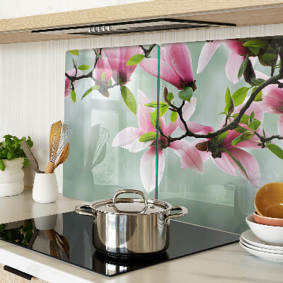 Schneidebrett mit Motiv aus Magnolienblüten vor grünem Hintergrund