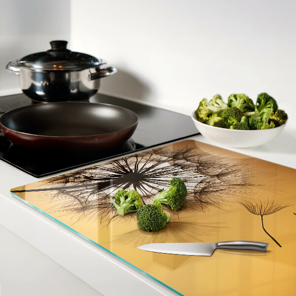 Schneidebrett Glas mit Löwenzahnmotiv vor dem Hintergrund eines Sonnenuntergangs