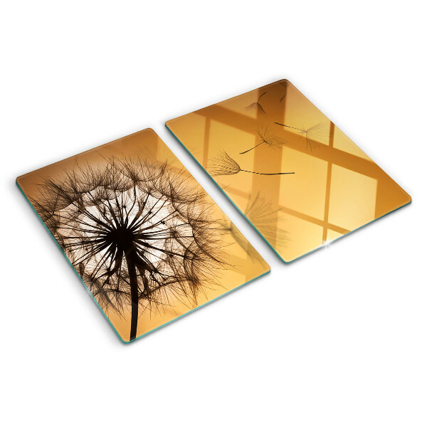 Schneidebrett Glas mit Löwenzahnmotiv vor dem Hintergrund eines Sonnenuntergangs