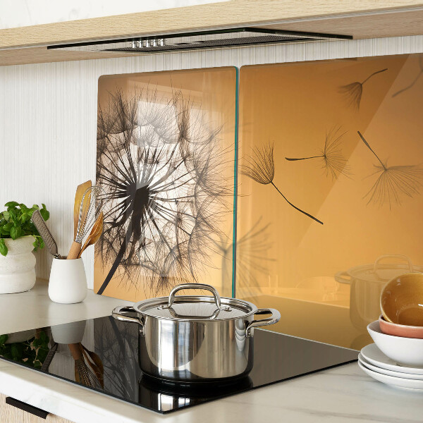 Schneidebrett Glas mit Löwenzahnmotiv vor dem Hintergrund eines Sonnenuntergangs