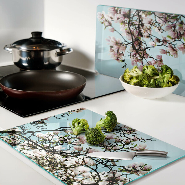 Glas schneidebrett Magnolienblüten auf blauem Hintergrund