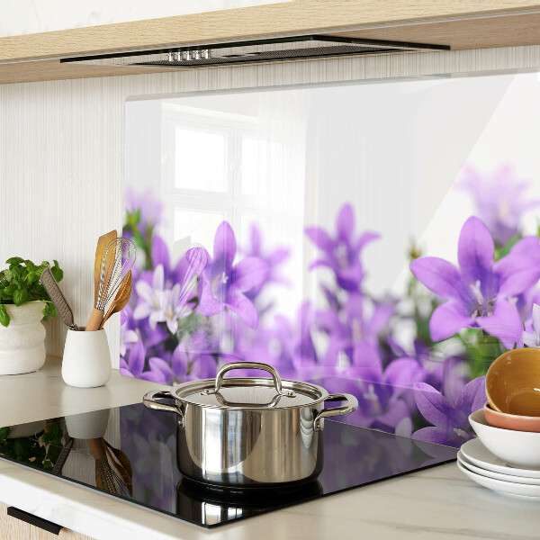 Glas-Schneidebrett mit lila Blumenmuster im Hintergrund