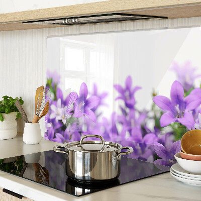 Glas-Schneidebrett mit lila Blumenmuster im Hintergrund