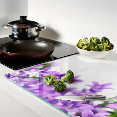 Glas schneidebrett Lila Blumen im Hintergrund