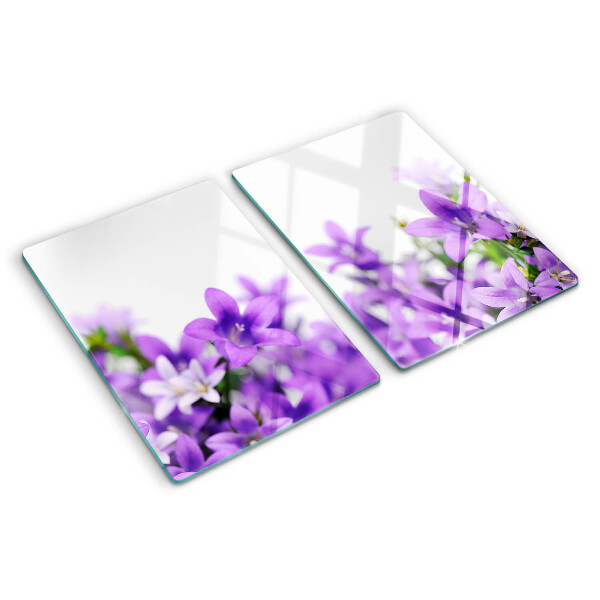 Glas-Schneidebrett mit lila Blumenmuster im Hintergrund