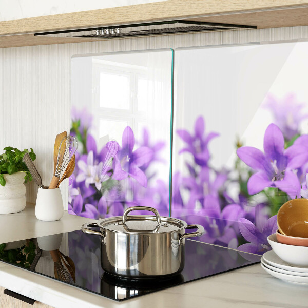 Glas-Schneidebrett mit lila Blumenmuster im Hintergrund