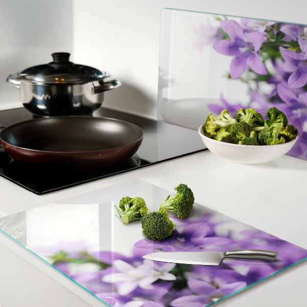 Glas schneidebrett Lila Blumen im Hintergrund