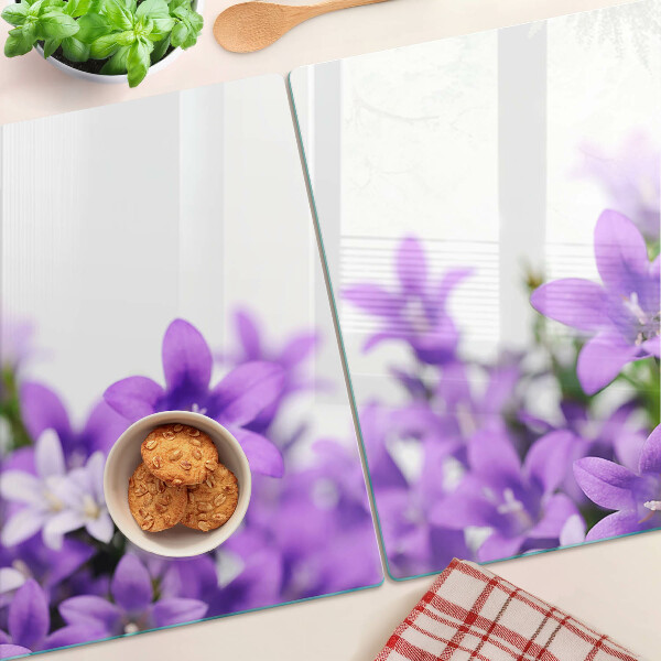 Glas schneidebrett Lila Blumen im Hintergrund