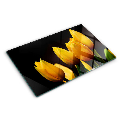 Schneidebrett mit gelben Tulpen auf schwarzem Hintergrund