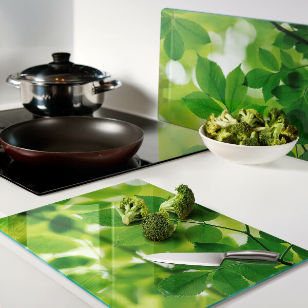 Schneidebrett mit Muster aus Blättern auf grünem Hintergrund