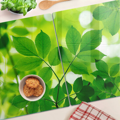 Schneidebrett mit Muster aus Blättern auf grünem Hintergrund