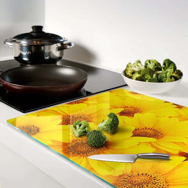 Schneidebrett Glas mit Sonnenblumen vor gelbem Hintergrund