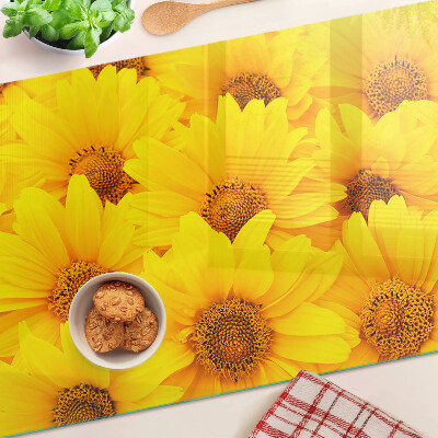 Schneidebrett Glas mit Sonnenblumen vor gelbem Hintergrund