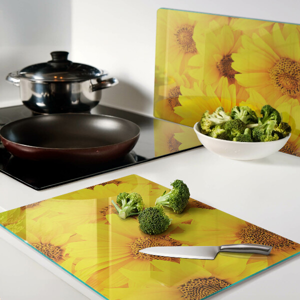 Schneidebrett Glas mit Sonnenblumen vor gelbem Hintergrund