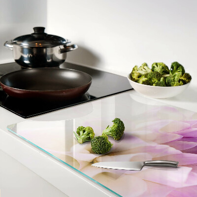 Glas-Schneidebrett mit einem Blumenarrangement in Lilatönen