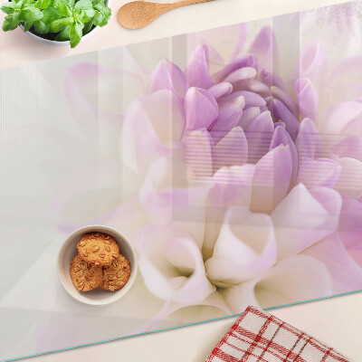 Glas-Schneidebrett mit einem Blumenarrangement in Lilatönen