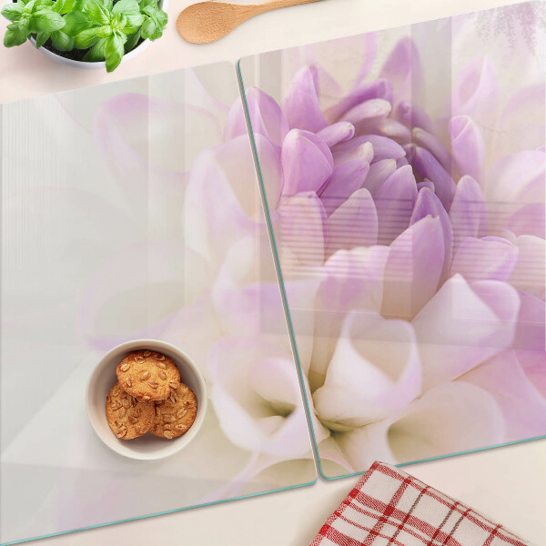 Glas-Schneidebrett mit einem Blumenarrangement in Lilatönen