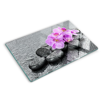 Schneidebrett mit Blumen- und Steindekor vor Wasserhintergrund