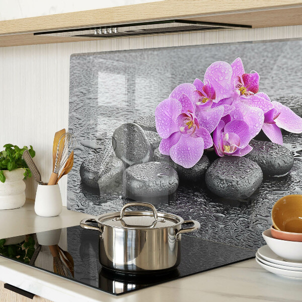 Schneidebrett mit Blumen- und Steindekor vor Wasserhintergrund