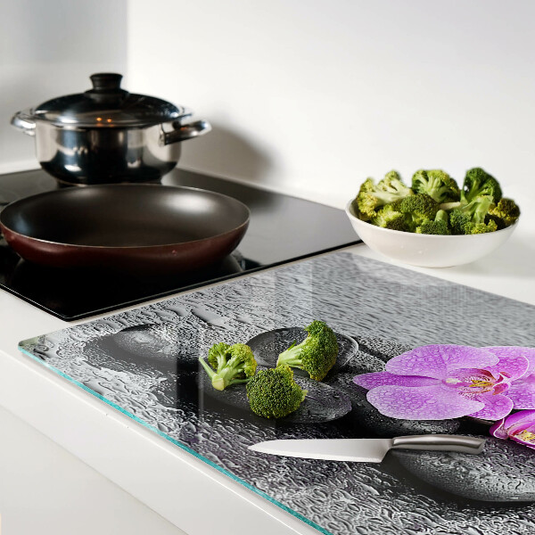 Schneidebrett Blumen und Steine ​​vor dem Hintergrund des Wassers