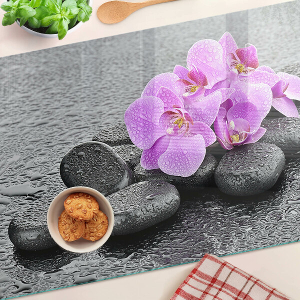 Schneidebrett Blumen und Steine ​​vor dem Hintergrund des Wassers