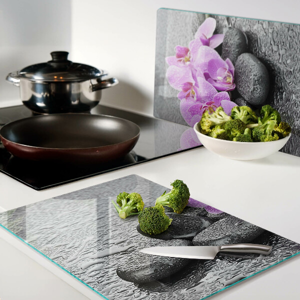 Schneidebrett Blumen und Steine ​​vor dem Hintergrund des Wassers