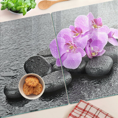 Schneidebrett Blumen und Steine ​​vor dem Hintergrund des Wassers