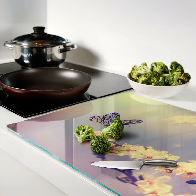 Schneidebrett Glas mit Schmetterlingsmotiv vor Blumenhintergrund