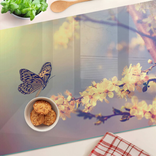 Schneidebrett Glas mit Schmetterlingsmotiv vor Blumenhintergrund