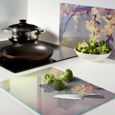 Schneidebrett Glas mit Schmetterlingsmotiv vor Blumenhintergrund