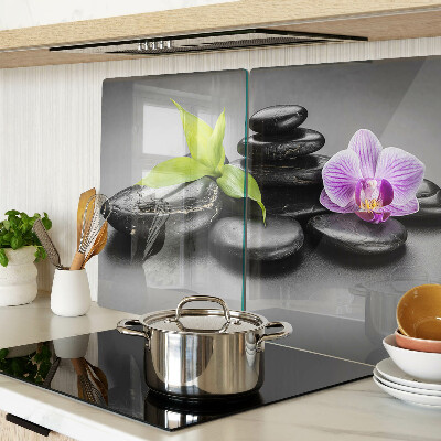 Schneidebrett Glas mit Steinen und Orchideen im Hintergrund