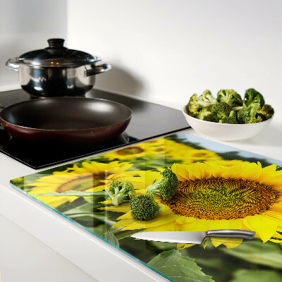 Schneidebrett glas Sonnenblumen vor grünem Hintergrund