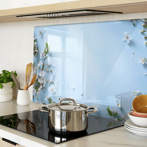 Glas-Schneidebrett mit Blumenmuster auf blauem Hintergrund