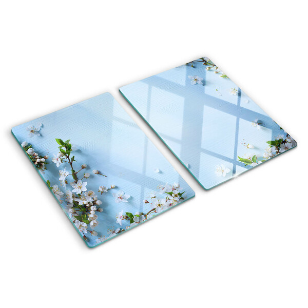Glas-Schneidebrett mit Blumenmuster auf blauem Hintergrund