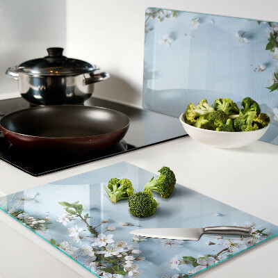 Glas-Schneidebrett mit Blumenmuster auf blauem Hintergrund