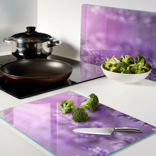 Schneidebrett Glas mit Lavendelblüten auf violettem Hintergrund