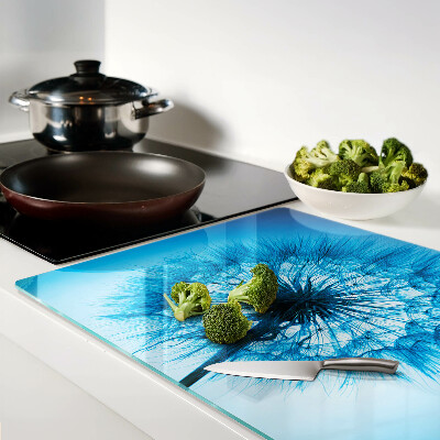 Glas-Schneidebrett mit Löwenzahn-Motiv auf blauem Hintergrund