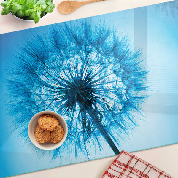 Glas schneidebrett Löwenzahn auf blauem Hintergrund