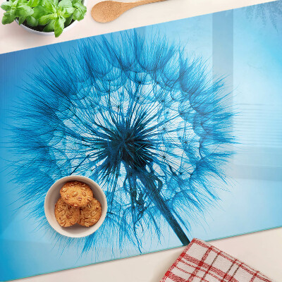 Glas-Schneidebrett mit Löwenzahn-Motiv auf blauem Hintergrund