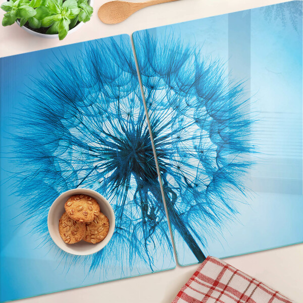 Glas schneidebrett Löwenzahn auf blauem Hintergrund