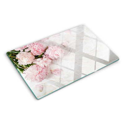 Glas-Schneidebrett mit Pfingstrosen auf marmoriertem Hintergrund