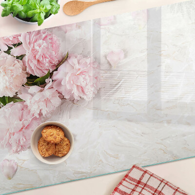 Glas-Schneidebrett mit Pfingstrosen auf marmoriertem Hintergrund