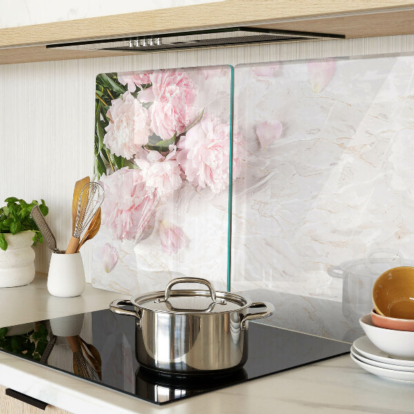 Glas-Schneidebrett mit Pfingstrosen auf marmoriertem Hintergrund